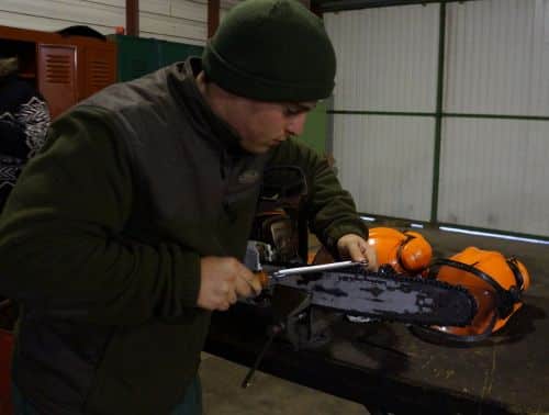 Élève du lycée forestier André Alquier manipulant une tronçonneuse dans le cadre d'un exercice pratique, apprenant les techniques de sécurité et d'entretien des équipements forestiers.